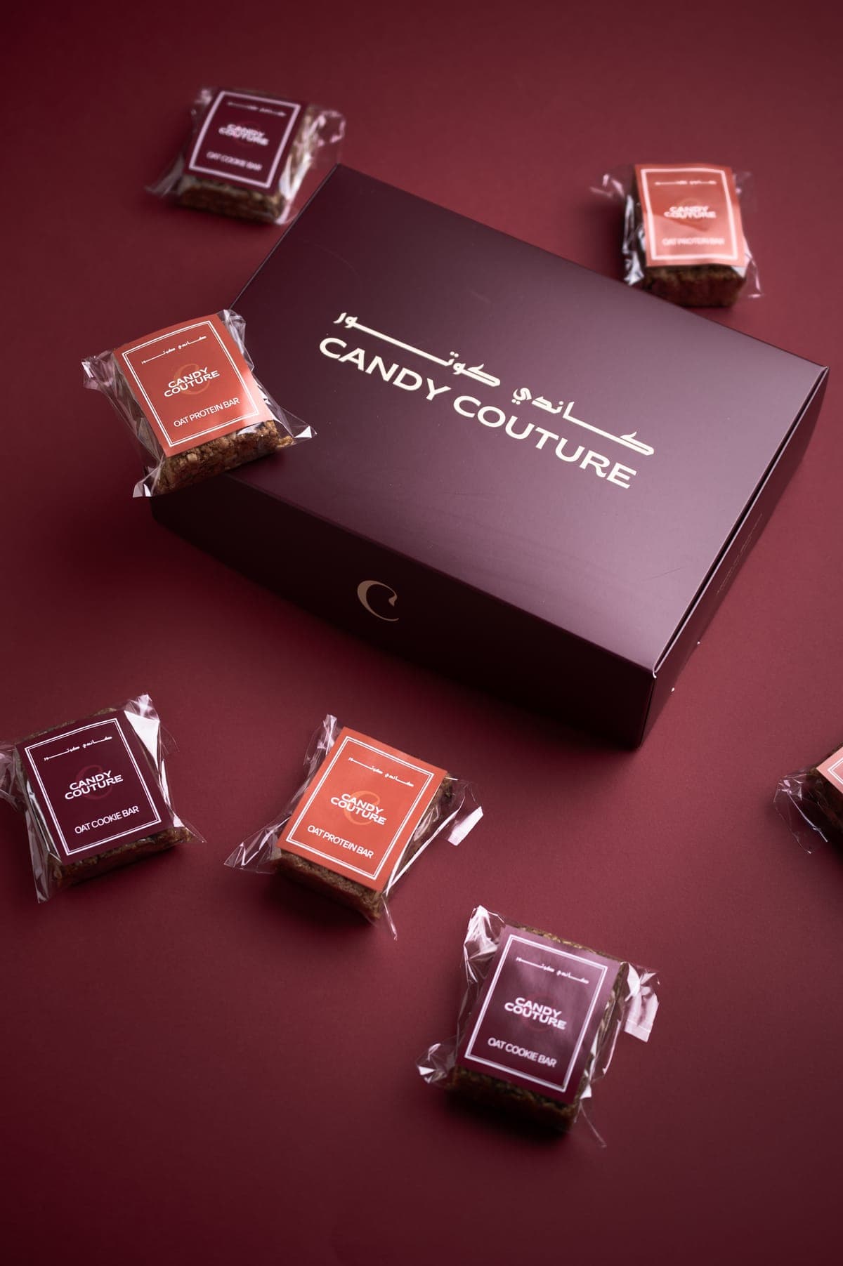 Candy Couture gift box surrounded by individually wrapped Oat Cookie Bars and Oat Protein Bars